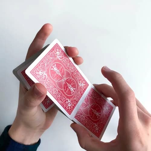 Hindu Shuffle: Die linke Hand zieht von oben einen kleinen Kartenpaket ab und lässt es in die Handfläche fallen