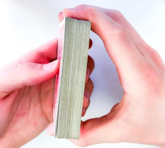 Daumen und Mittelfinger greifen an den beiden kurzen Seiten das Deck