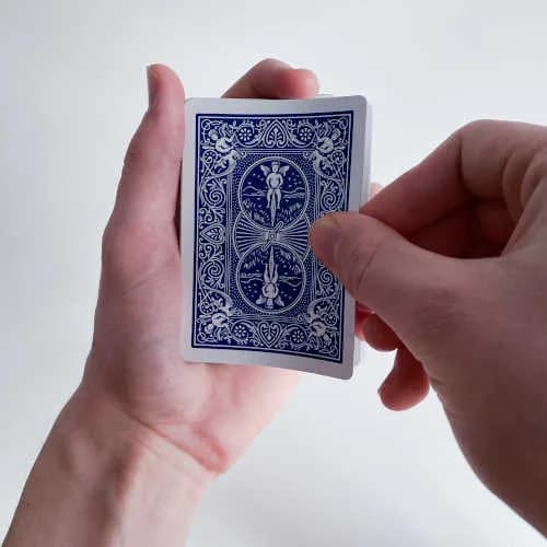 Karten werden mit Daumen, Zeige und Mittelfinger genommen