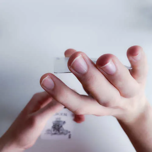 Nahaufnahme der Finger, die die untere Karte verdeckt austauschen, während der Blick oben liegt